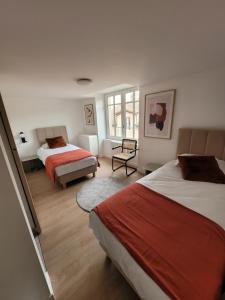 a hotel room with two beds and a window at Les Appartements de Millau in Millau