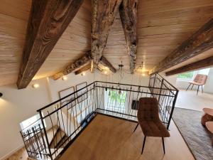 a room with wooden ceilings and a staircase with a chair at Les Appartements de Millau in Millau