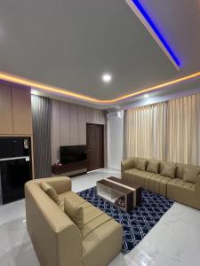 a living room with two couches and a tv at Milano Villas Puncak in Puncak