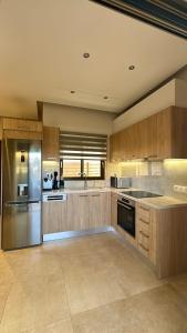 a large kitchen with wooden cabinets and stainless steel appliances at Ionian Waves Villa - Marathopoli Stylish Escape in Marathopoli