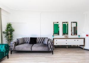 a living room with a couch and two mirrors at Melissas Suites Lara in Antalya +289 photos
