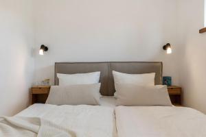 two beds in a bedroom with white sheets and pillows at Luxus-Ferienwohnung DS11 in Fehmarn