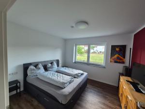 a bedroom with a bed and a window at Ferienhaus "Pusteblume" - Entspannen in Weiterode in Bebra