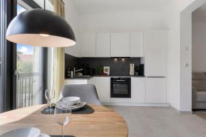 a kitchen with a dining table with a black lamp at Luxus-Ferienwohnung DS11 in Fehmarn