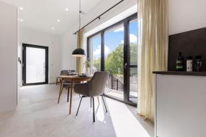 a dining room with a table and chairs and a large window at Luxus-Ferienwohnung DS11 in Fehmarn