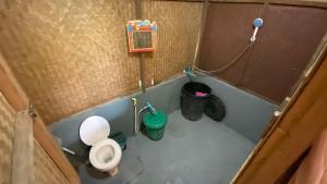 a small bathroom with a toilet and two trash cans at Poopha home stay in Amphoe Pai