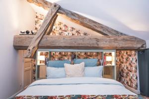 a bedroom with a bed with a wooden headboard at Maison Vitis in Fuissé