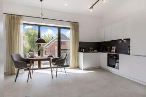 a kitchen and dining room with a table and chairs at Luxus-Ferienwohnung DS11 in Fehmarn +18 photos