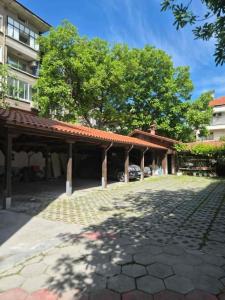 a pavilion with a car parked in a parking lot at Хотел М in Asenovgrad