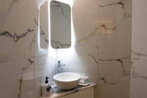 a bathroom with a sink and a mirror at LUM Luxury Studios in Rethymno +20 photos