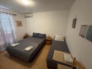 two beds in a small room with a window at Casa Julia in Herceg-Novi