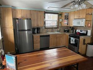 a kitchen with wooden cabinets and a stainless steel refrigerator at THE OHANA at BIG BEAR in Big Bear City