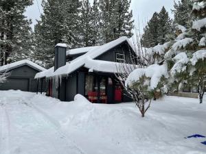 a house covered in snow with a pile of snow at THE OHANA at BIG BEAR in Big Bear City