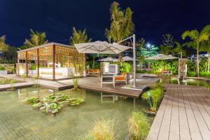 a pavilion with tables and umbrellas at night at Crowne Plaza Vientiane by IHG in Vientiane