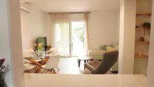 a living room with a table and chairs at Amazing apartment direct pool acces in Denia