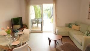 a living room with a couch and a table at Amazing apartment direct pool acces in Denia