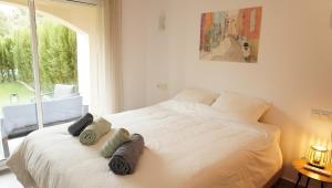a bedroom with a white bed with towels on it at Amazing apartment direct pool acces in Denia +32 photos