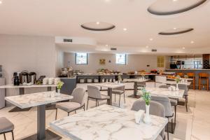 a restaurant with tables and chairs and a kitchen at White Hill Hotel in Tbilisi City
