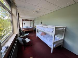 a room with two bunk beds and a window at Het Huis van Bewustzijn in Limmen