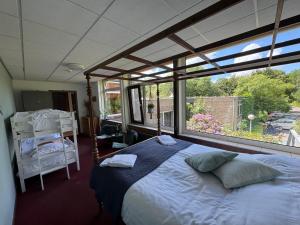 a bedroom with a bed and a large window at Het Huis van Bewustzijn in Limmen