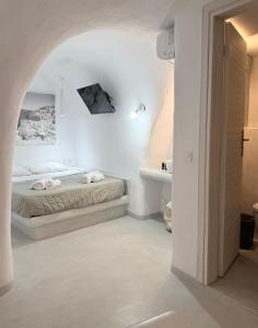 a white bedroom with a bed and a sink at Fira Value Rooms- Fira Center- Capital Santorini in Fira