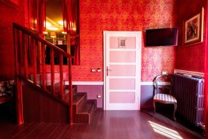 a red room with a white door and stairs at Rubra in Santerno