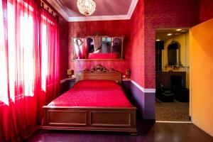 a red bedroom with a red bed with a mirror at Rubra in Santerno