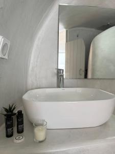 a white sink in a bathroom with a mirror at Fira Value Rooms- Fira Center- Capital Santorini in Fira