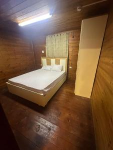 a bedroom with a bed in a room with wooden floors at carmel cabins suite 3 in Yājur +23 photos