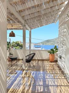 a patio with a pergola and a table and chairs at Manifesto Seaview Apartment II in Kalymnos