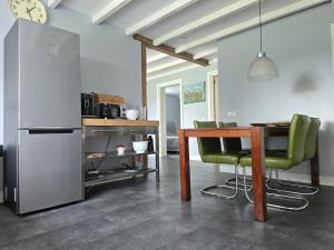 a kitchen with a table and a refrigerator at Vinkelaar 11 in Terschuur