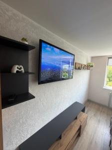 a living room with a flat screen tv on the wall at U-Home in Verkhovyna