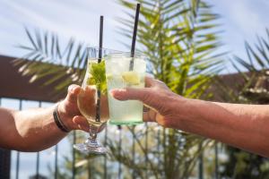 two people holding up two glasses of drinks at Côté Lac Hostel Evian in Évian-les-Bains