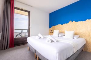two beds in a room with a blue wall at Côté Lac Hostel Evian in Évian-les-Bains +58 photos