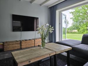 a living room with a vase of flowers on a table at Vinkelaar 11 in Terschuur