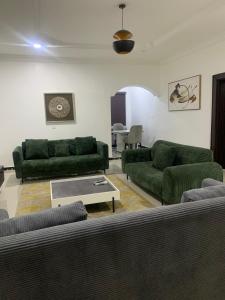 a living room with green couches and a table at Beacon Shortlet in Kaduna +1 photo