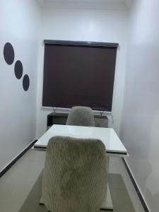 a conference room with a table and chairs and a large screen at Beacon Shortlet in Kaduna