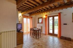 a living room with a television and a table with chairs at Agriturismo Il Barco in Spello