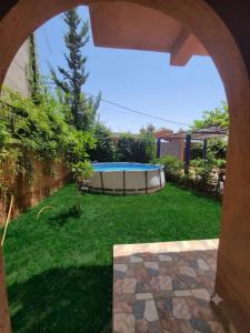 a backyard with a swimming pool in the grass at Villa RAHA villa entière in El Aggada