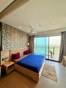 a bedroom with a blue bed and a large window at Nova Spira in Noida