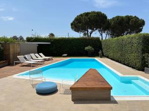 a large swimming pool with chairs and a table at Luxury Swimming Pool in Fontane Bianche