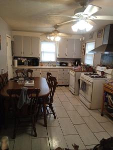 a kitchen with a table and a kitchen with a stove and a sink at Cws seperate entrance in Omaha