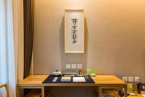 a table in a room with a picture on the wall at Mainland Chinese Only-Qinhuangdao Xinting Calligraphy Hotel in Qinhuangdao