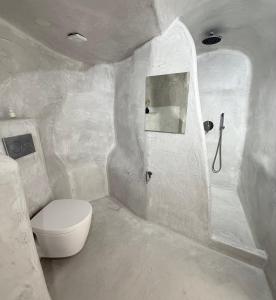 a white bathroom with a toilet and a sink at Fira Value Rooms- Fira Center- Capital Santorini in Fira