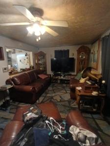a living room with leather couches and a flat screen tv at Cws seperate entrance in Omaha