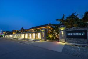 a building with a sign on the side of it at Mainland Chinese Only-Qinhuangdao Xinting Calligraphy Hotel in Qinhuangdao