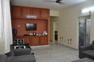 a living room with two chairs and a tv at Haritha Apartments Family-Only Apartments in Tirupati, Big Families, Groups Welcome in Tirupati