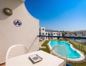 a balcony with a table and chairs and a swimming pool at Home2Book Aloha Palm in Costa Calma