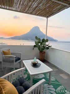 a table and chairs on a balcony with a view of the beach at Manifesto Seaview Apartment I in Kalymnos