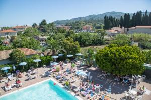 einen Blick über den Pool mit Personen und Sonnenschirmen in der Unterkunft Hotel Delle Mimose in Diano Marina